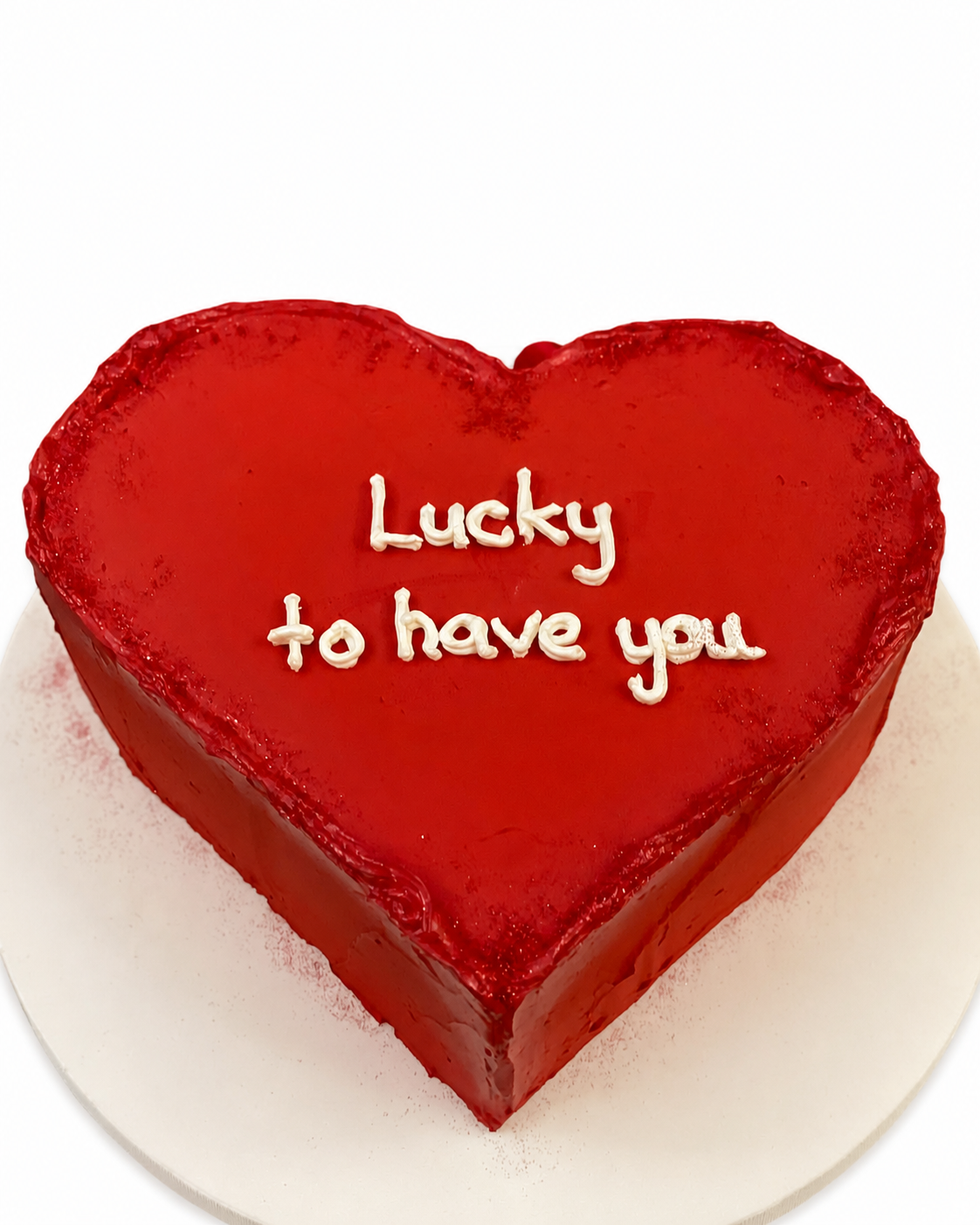 Beyaz arka planda kırmızı kalp şeklinde Lucky to Have You mesajlı pasta