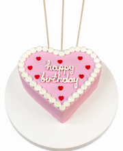 Beyaz arka planda pembe kalp şeklinde kırmızı kalpli Happy Birthday pastası