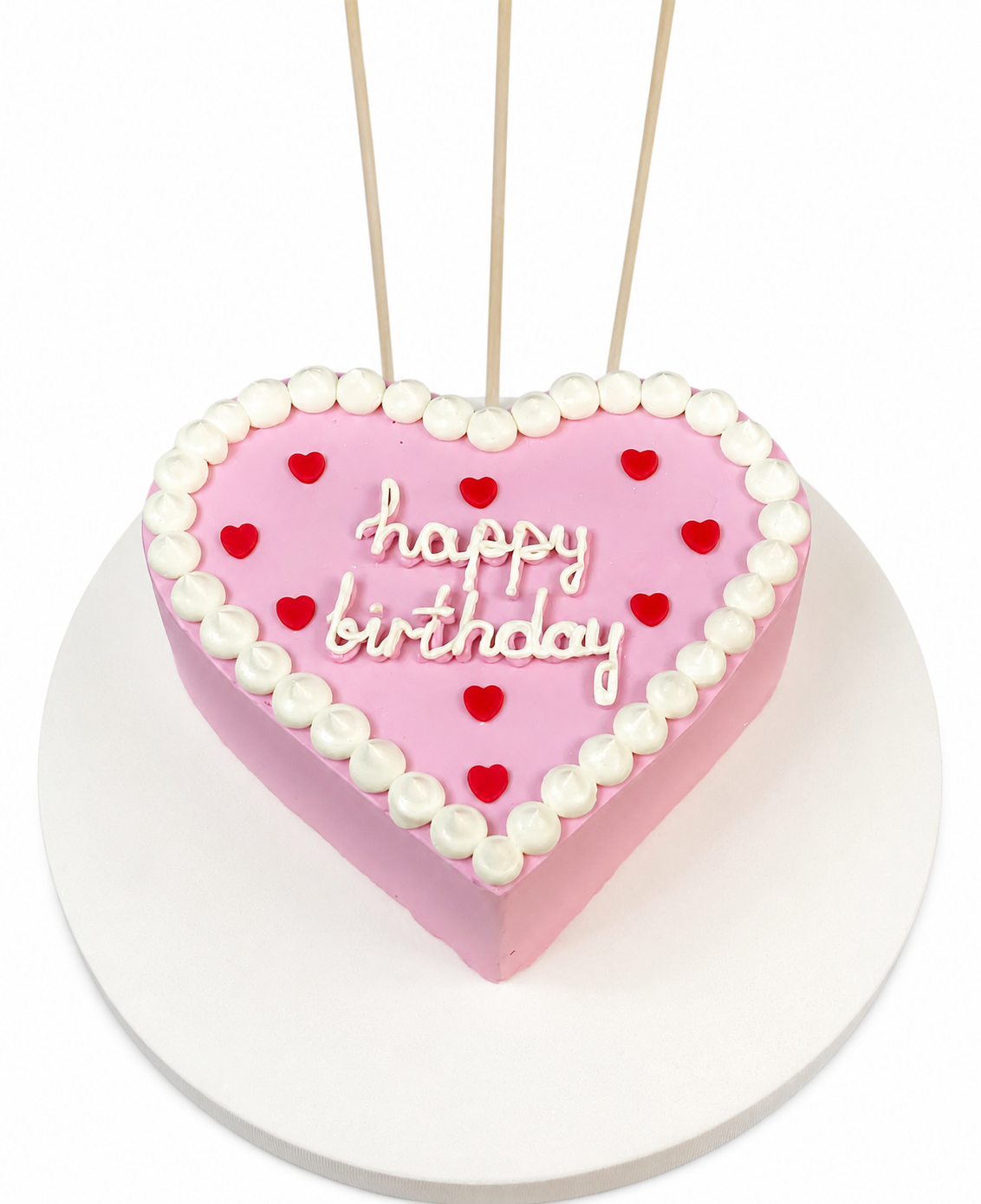 Beyaz arka planda pembe kalp şeklinde kırmızı kalpli Happy Birthday pastası
